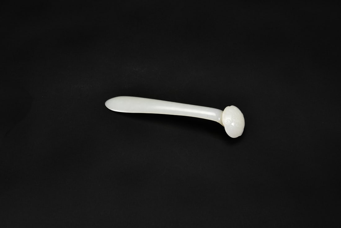 A White Jade Ruyi-Head Hairpin Carved with Shou Character, Qing Dynasty (18th?19th Century): Carved from translucent white jade, the slender hairpin terminates in a ruyi-shaped head incised with a shou character amid scrolling motifs. Smoothly polished and elegantly refined, typical of Qing-p