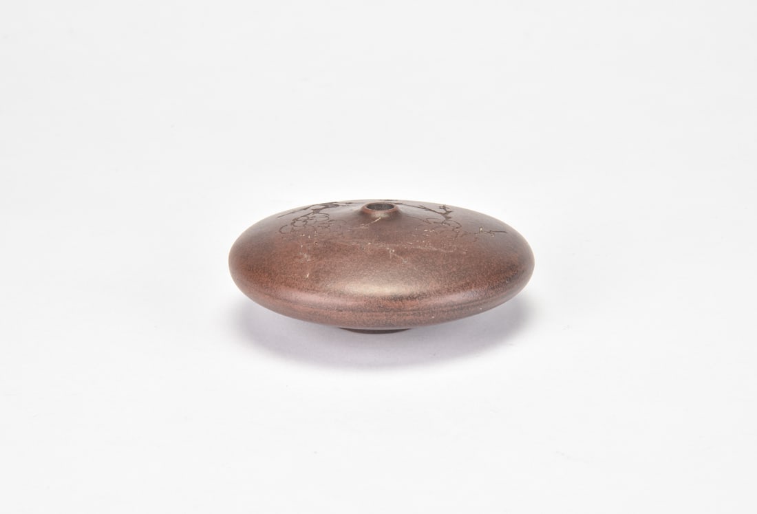 A Yixing Zisha Incised Prunus Water-Pipe Fitting: Of compressed circular form, the Yixing stoneware fitting is potted with a rounded body and a raised circular opening for attachment. The surface is finely incised with flowering prunus branches,