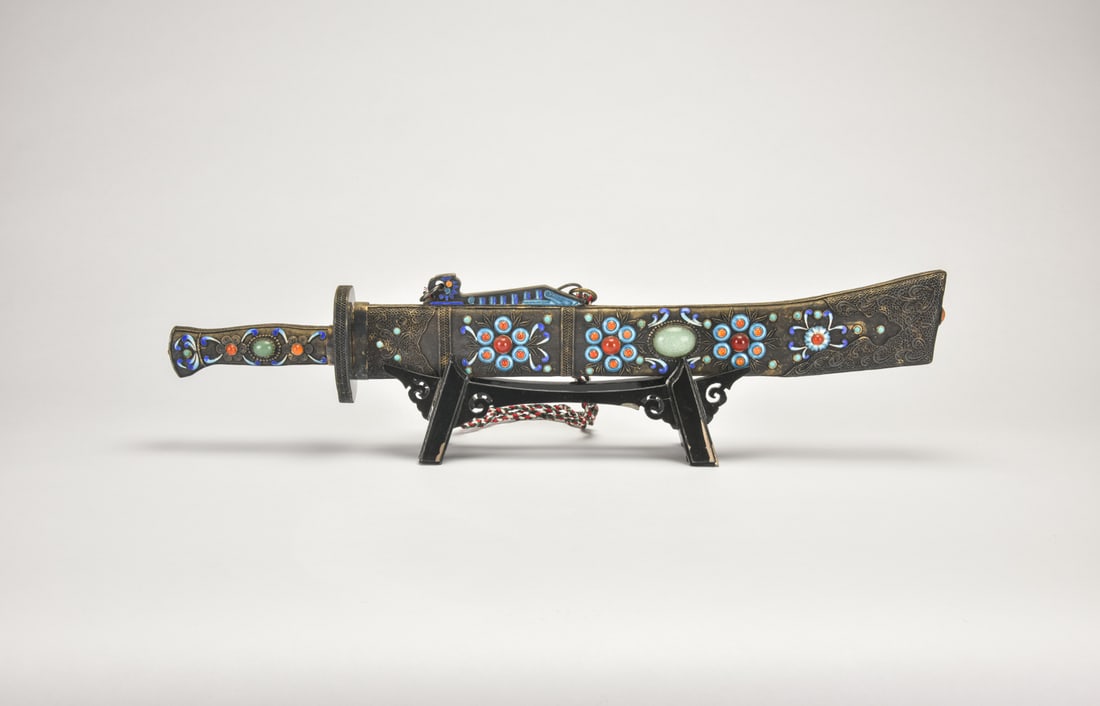 A Group of Three Snuff Bottles. Late Qing Dynasty?Republic Period: This group comprises two silver-mounted metal snuff bottles embellished with coral and turquoise cabochons, together with one carved rose quartz snuff bottle decorated with flowering branches. The