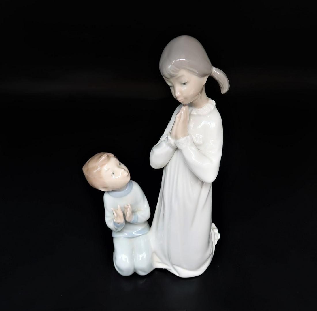 by LLadro " Teaching To Pray" Collectible Figurine: by LLadro " Teaching To Pray" Collectible Figurine #04779 retired glazed finish, hand made in Spain sculptor by VICENTE MARTINEZ; issued in 1971 and retired in 1998. size: 8 3/4" x 4" x 3 3/4".