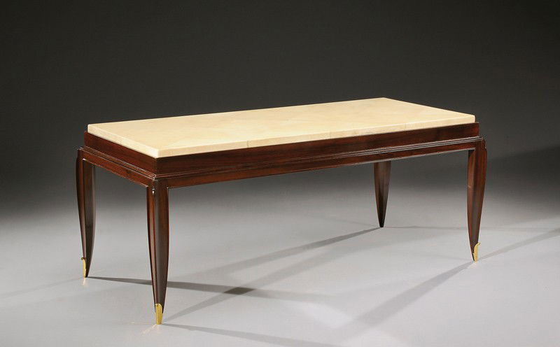 JEAN PASCAUD (1903-1996): A rectangular coffee table in Indian rosewood veneer and parchment with gilded bronze sabots. Circa 1940. 19 in. (48 cm) high, 44 1/2 in. (113 cm) wide, 20 2/3 in. (51 cm) depth