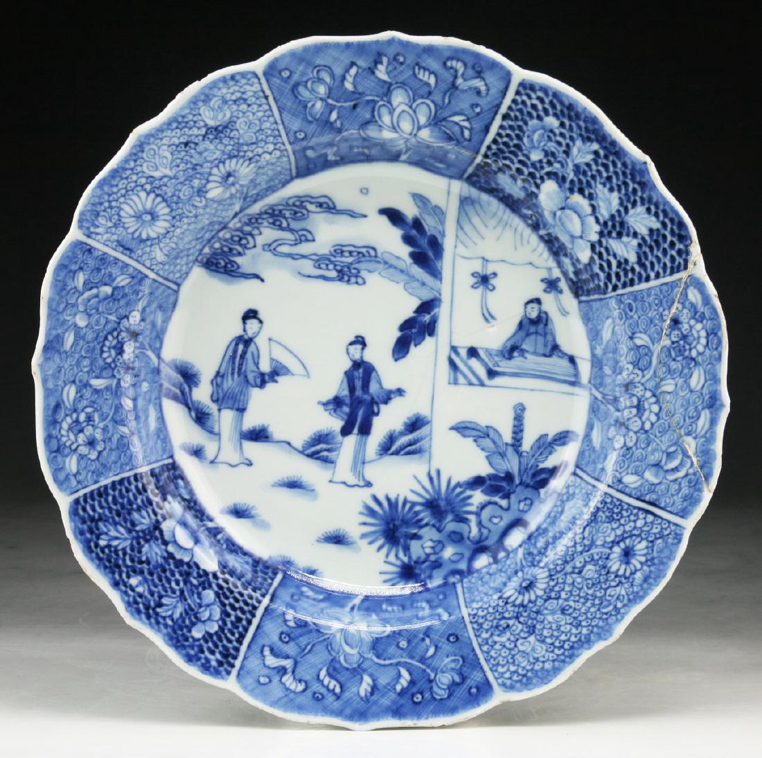 A CHINESE ANTIQUE BLUE & WHITE PORCELAIN PLATE: A Chinese Antique Blue & White Porcelain Plate: The interior Finely Painted With Figures Amid A Courtyard Bordered By Panels Of Various Blossoming Branches, The Exterior And Base Painted With Flowers,