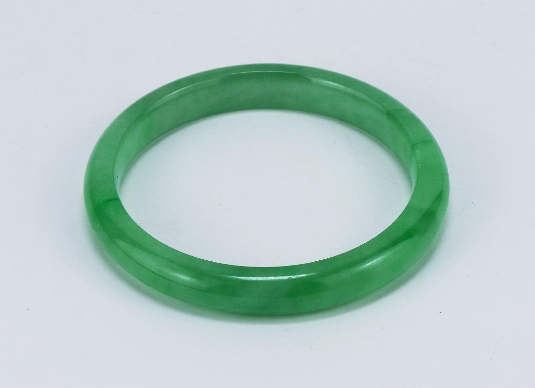 A GREEN JADEITE CARVED BANGLE (1 of 2)