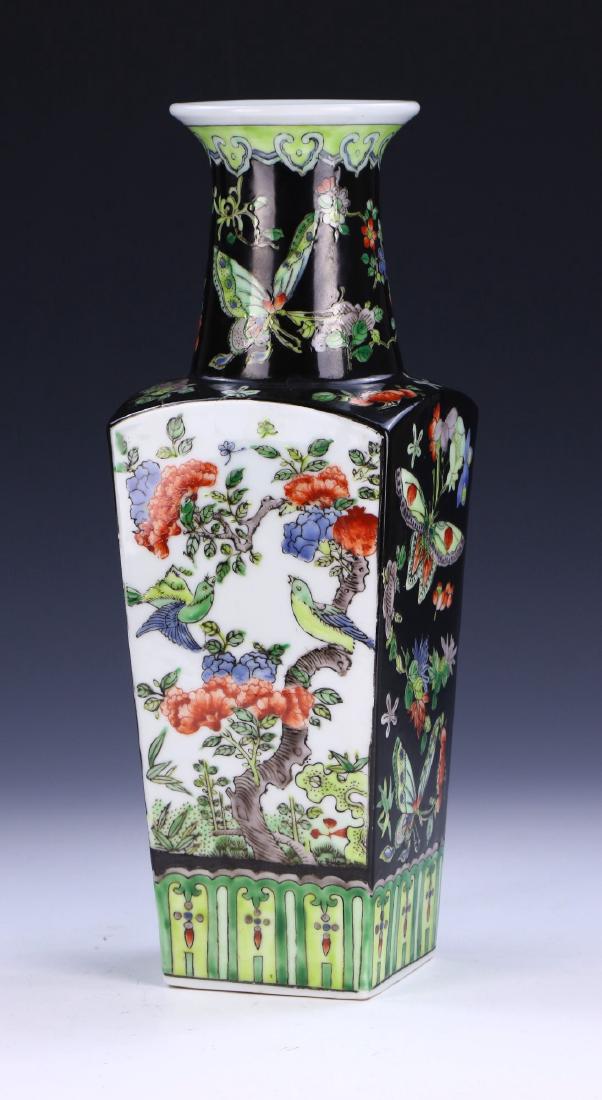 A CHINESE ANTIQUE FAMILLE ROSE PORCELAIN VASE: A Chinese Antique Famille Rose Porcelain Vase: Of Squared Form Rising To A Flared Rim, The Exterior Finely Painted With Birds And Butterflies Amid Blossoming Branches On A Black Glazed Ground; Size: H
