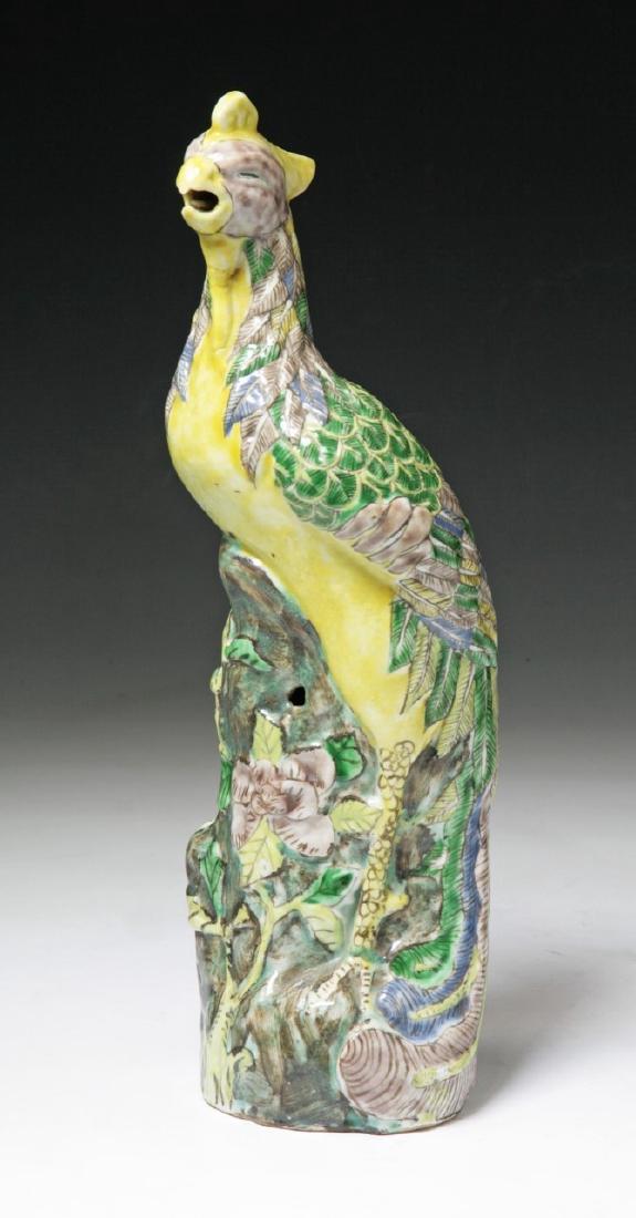 A CHINESE ANTIQUE FAMILLE ROSE PORCELAIN PHOENIX: A Chinese Antique Famille Rose Porcelain Phoenix: Well Potted As A Phoenix Perched Amid Rockery And Sprouting Blossoms, Of Qing Dynasty; Size: H: 12-3/4" (32.39cm)