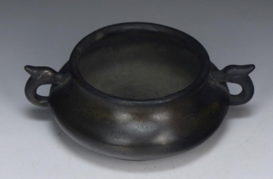 A CHINESE ANTIQUE BRONZE TRIPOD CENSER: A Chinese Antique Bronze Tripod Censer: The Compressed Body Supported On Low Feet, The Rim Surmounted By Two Chi Dragon Shaped Handles, The Base incised With A Four Character inscription 'Da Ming xuan