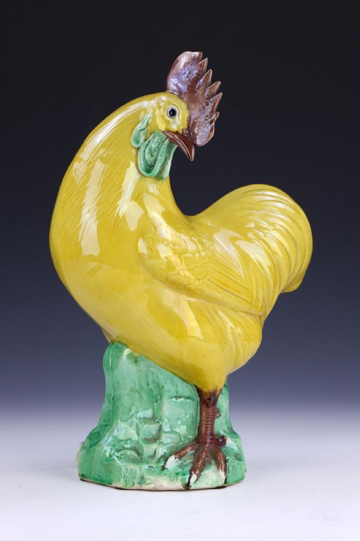A CHINESE ANTIQUE YELLOW & GREEN GLAZED PORCELAIN: A Chinese Antique Yellow & Green Glazed Porcelain Chicken: Finely Molded As A Yellow Chicken Standing With Its Head Turned Towards The Left While Resting On A Rising Green Glazed Rockery Plinth; Size: