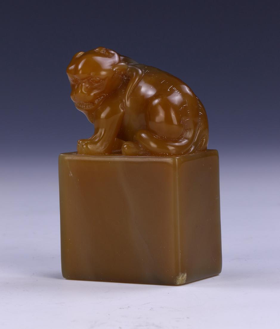 A CHINESE SOAPSTONE CARVED SEAL: A Chinese Soapstone Carved Seal: Of Rectangular Form, Rising To A Finely Carved Lion Dog, The Stone Of Mixed Medium Brown To Dark Grey Tones; Size: H: 2-1/2" (6.35cm)