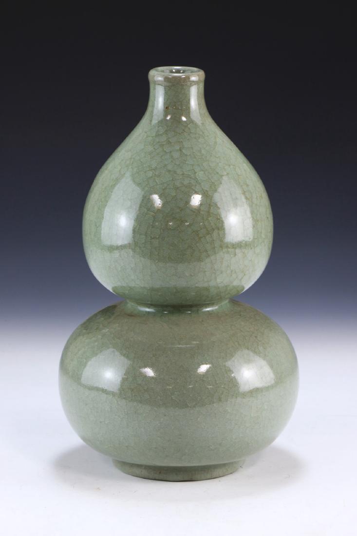 A CHINESE ANTIQUE CELADON GLAZED PORCELAIN VASE: A Chinese Antique Celadon Glazed Porcelain Vase: Of Gourd Form Rising To A Cylindrical Rim, The Body Finely Finished With A Crackle Celadon Glaze Throughout; Size: H: 12" (30.48cm)