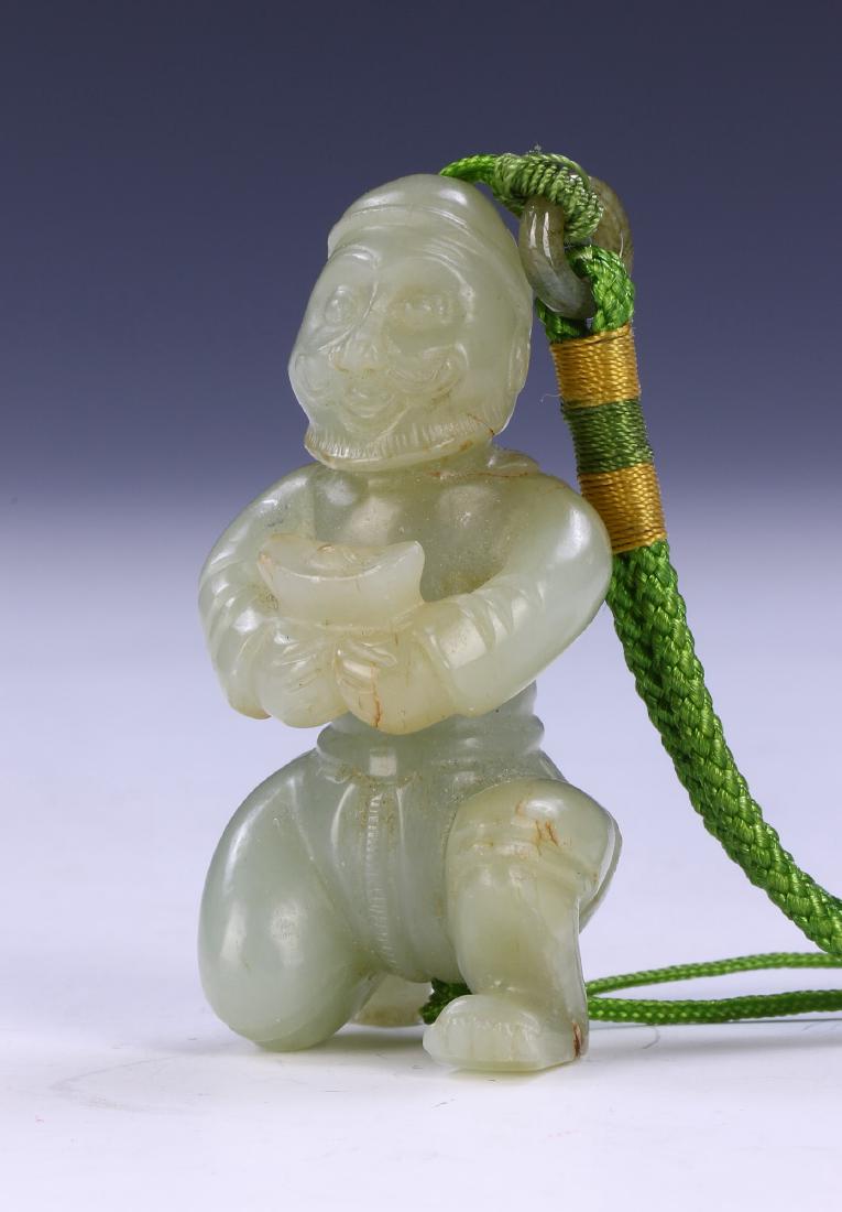 A CHINESE JADE CARVED PENDANT: A Chinese Jade Carved Pendant: Finely Carved As A Bearded Man Kneeling Holding A Yuan Bao, The Jade Of Mixed Pale Green Tones With Mottled Light Brown To Grey Spots; Size: H: 2-1/2" (6.35cm)