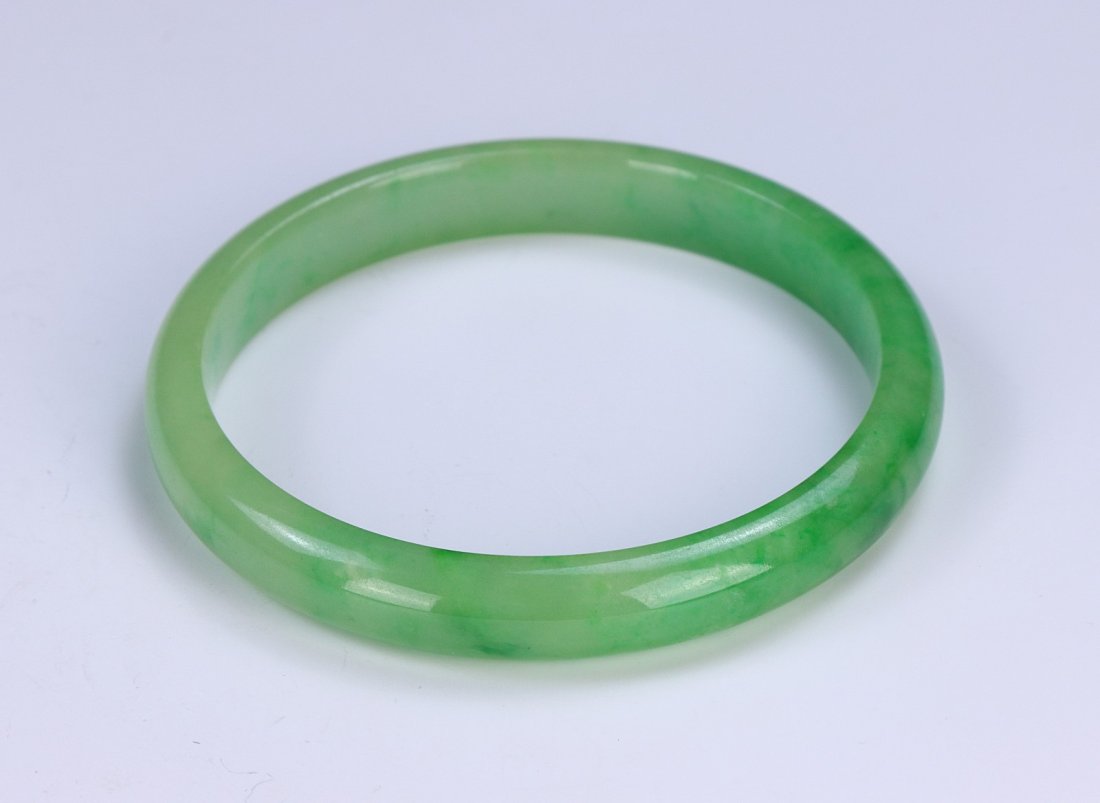 A CHINESE GREEN JADEITE BANGLE (1 of 2)