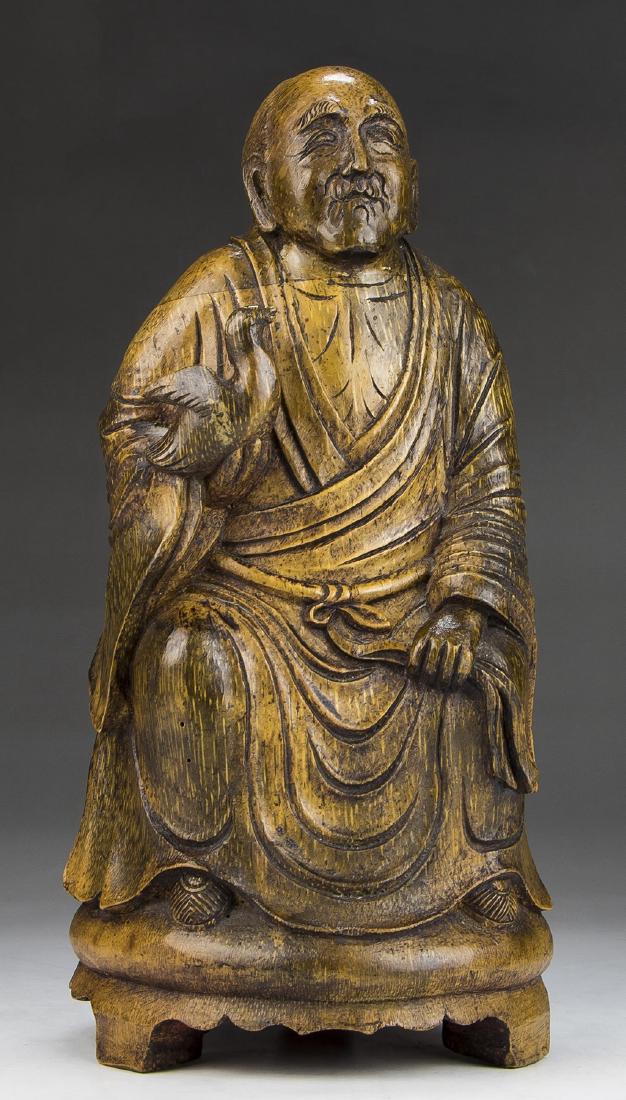 A CHINESE BAMBOO CARVED FIGURE: A Chinese Bamboo Carved Figure: Finely Carved, Shown Rising From A Domed Plinth Rested On Three Low Feet, Draped in Traditional Robes With Bird in Right Hand; Size: H: 9-3/4" (24.77cm)