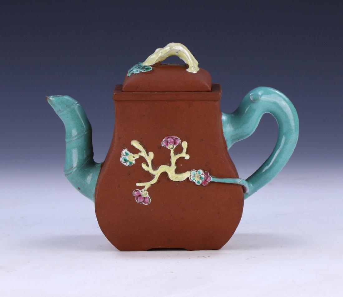 A CHINESE ANTIQUE YIXING POLYCHROME ZISHA TEAPOT: A Chinese Antique Yixing Polychrome Zisha Teapot: Of Squared Pear Shape, Body Finely Molded With Sprouting Flowers And Bamboo Stalks Set in High Relief, Blossom Sign incised On The Base Within A Squar