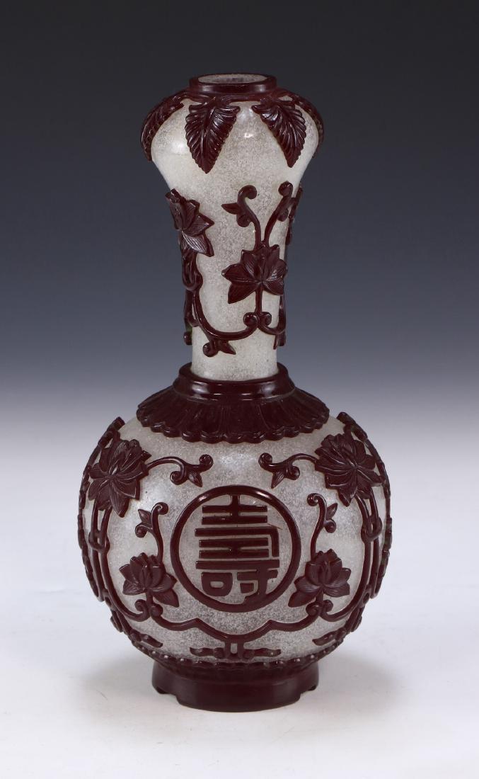 A CHINESE ANTIQUE OVERLAY PEKING GLASS VASE: A Chinese Antique Overlay Peking Glass Vase: Of Ovoid Form, Rising To A Slim Neck And Garlic Head Rim, Semi-Translucent Glass Overlaid With Skillfully Carved Red Medallions Amid Sprouting Lotus Blosso
