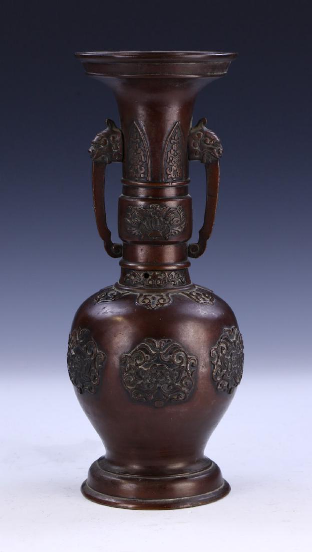 A JAPANESE ANTIQUE BRONZE VASE: A Japanese Antique Bronze Vase: Body Of Ovoid Form, Rising To A Cylindrical Neck Flanked On Each Side By Menacing Animal Head Form Handles, Finely Cast With Blooming Flower Panels Amid Continuous Vine