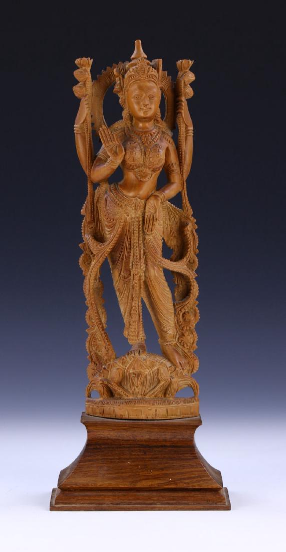 AN INDIAN ANTIQUE WOOD FIGURE: An indian Antique Wood Figure: A indian Antique Wood Figure: Finely Carved, The Wood Of A Consistent Light Tone, Presented On A Wood Stand; Size: H: 14-3/4" (37.47cm)