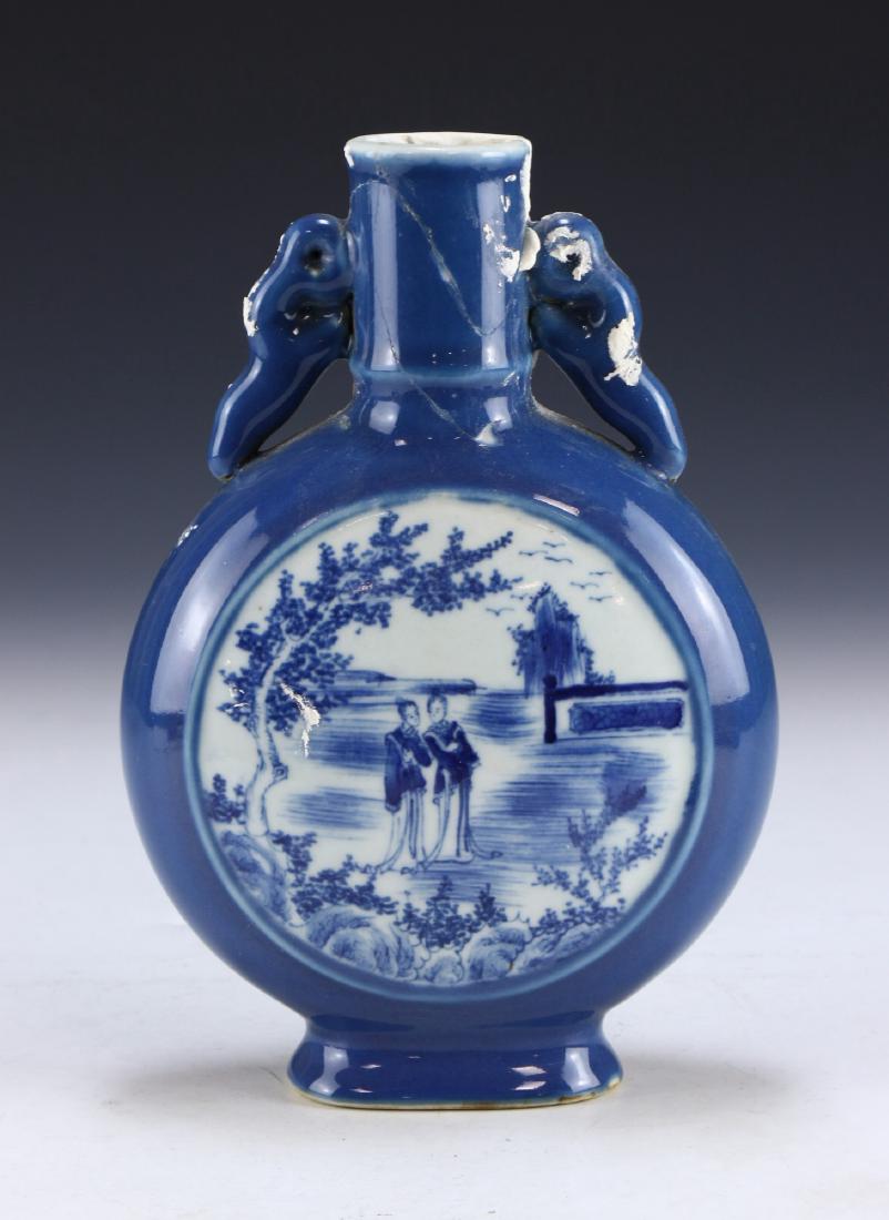 A CHINESE ANTIQUE BLUE & WHITE PORCELAIN MOON FLASK: A CHINESE ANTIQUE BLUE & WHITE PORCELAIN MOON FLASK: of circular form, rising from an ovoid base to a cylindrical neck flanked on both sides by elegant scrolling handles, body finely painted with a la