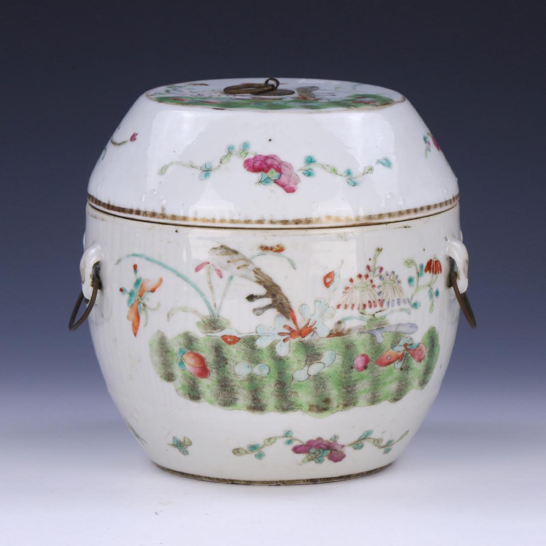 A CHINESE ANTIQUE FAMILLE ROSE LIDDED PORCELAIN JAR: A Chinese Antique Famille Rose Lidded Porcelain Jar: Of Ovoid Form, Wide Neck Flanked On Each Side By Loose Ring Handles, Body And Cover Finely Painted With Blooming Flowers Amid Plant Stalks; Size: H