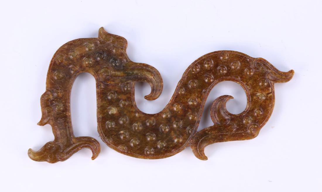 A CHINESE ANTIQUE ARCHAIC JADE CARVED DRAGON: A Chinese Antique Archaic Jade Carved Dragon: Finely Carved As A Swirling Dragon, The Jade Of Brown And Green Tones; Size: L: 5" (12.7cm)
