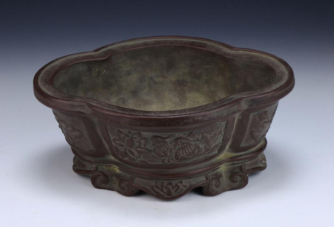 A Chinese Antique Zisha Planter: A Chinese Antique Zisha Planter: Of Shallow Leaf Form, The Exterior With Raised Panels Of Ducks And Lotus Blossoms, The Bottom Lifted By Scalloped Edges And Lotus Designs, incised Qianlong On The Base