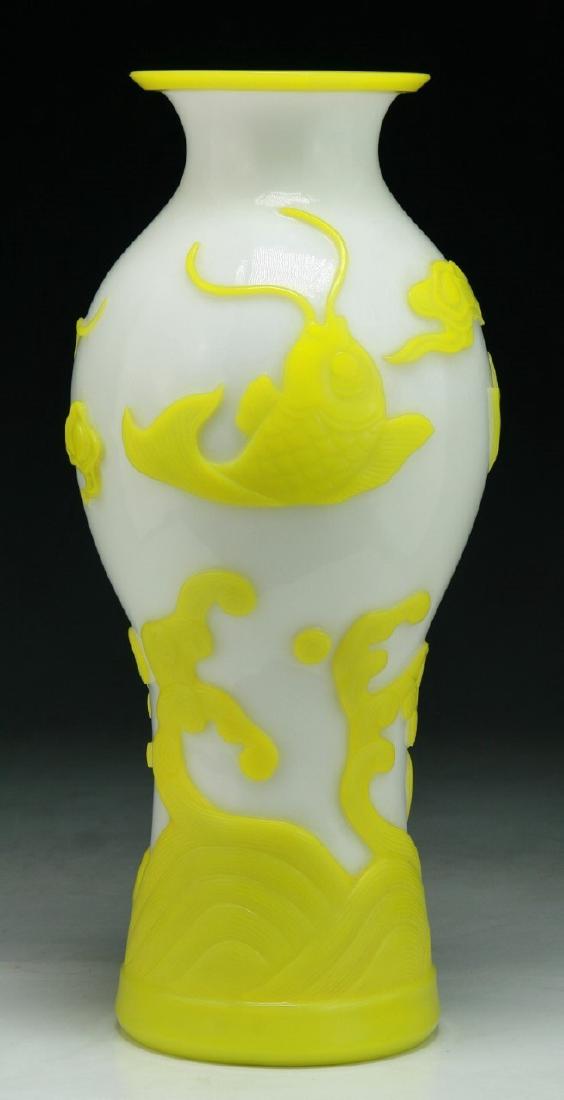 A CHINESE ANTIQUE CARVED OVERLAY PEKING GLASS VASE: A Chinese Antique Carved Overlay Peking Glass Vase: Skillfully Carved Through The Yellow Peking Glass To The Milky White Ground With The Scene Of Fish Jumping Over Cresting Waves; Size: H: 12-3/4" (32