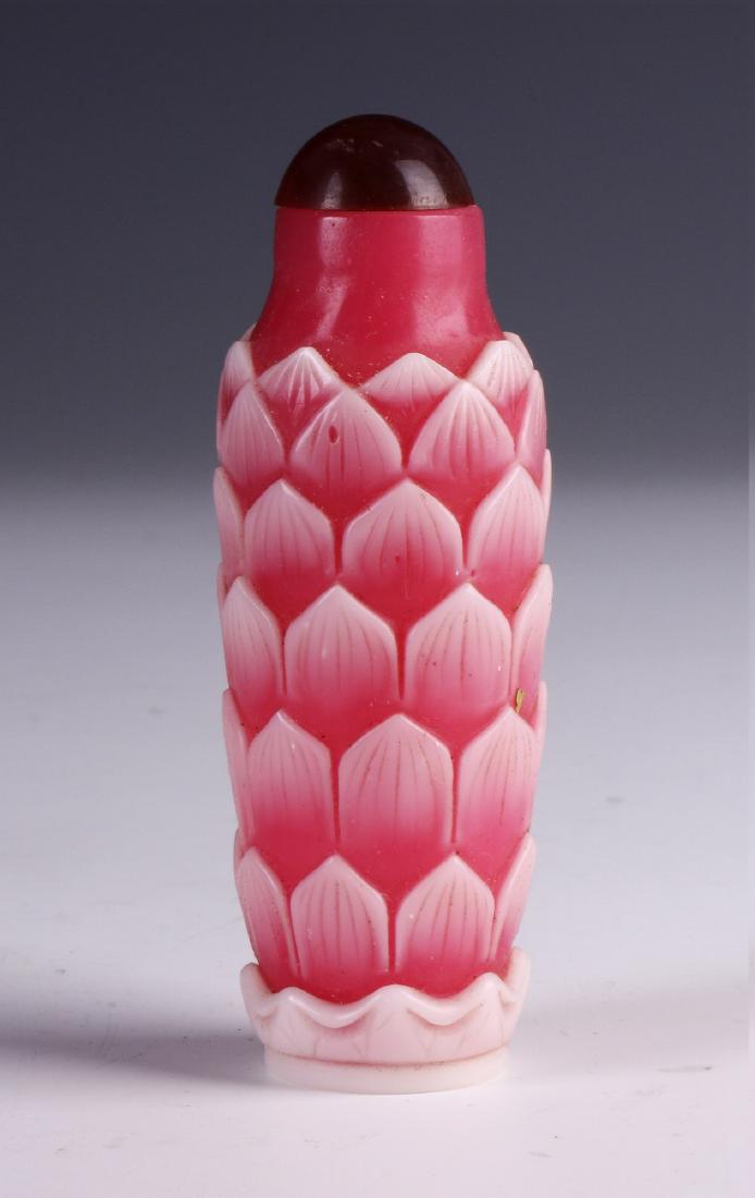 A CHINESE ANTIQUE PINK PEKING GLASS SNUFF BOTTLE: A Chinese Antique Pink Peking Glass Snuff Bottle: Of Cylindrical Form, Rising To A Red Domed Stopper, Body Finely Overlaid in A Leaves Motif, Four Character Mark Carved On The Base; Size: H: 3-1/2" (8