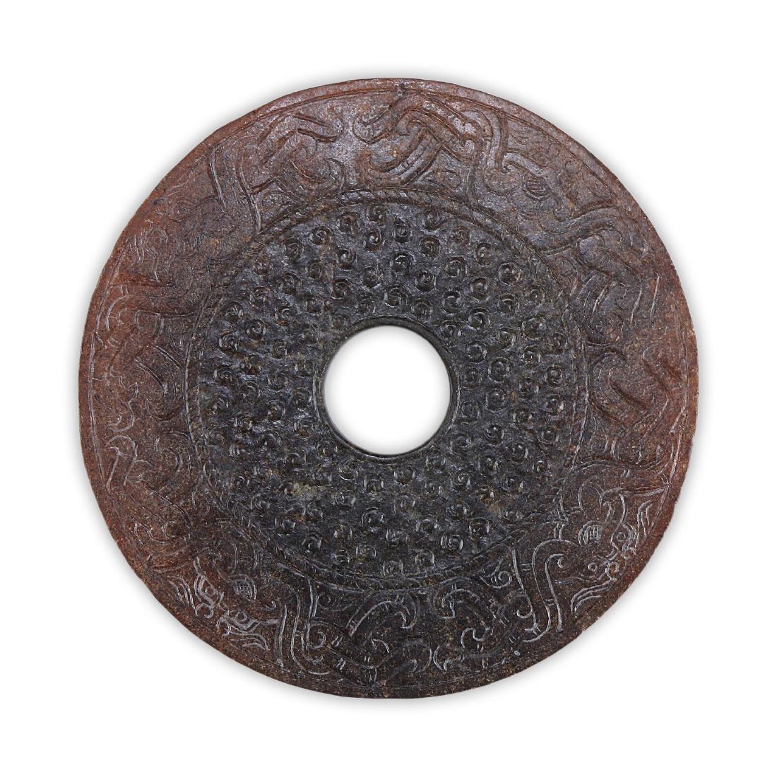 A CHINESE ANTIQUE ARCHAIC JADE BI: A Chinese Antique Archaic Jade Bi: Of Circular Form, Each Side Of The Body Finely Carved With Horned Celestial Animals Amid A Dotted Finish, The Opaque Jade Of Mixed Medium Brown To Dark Green Tones;