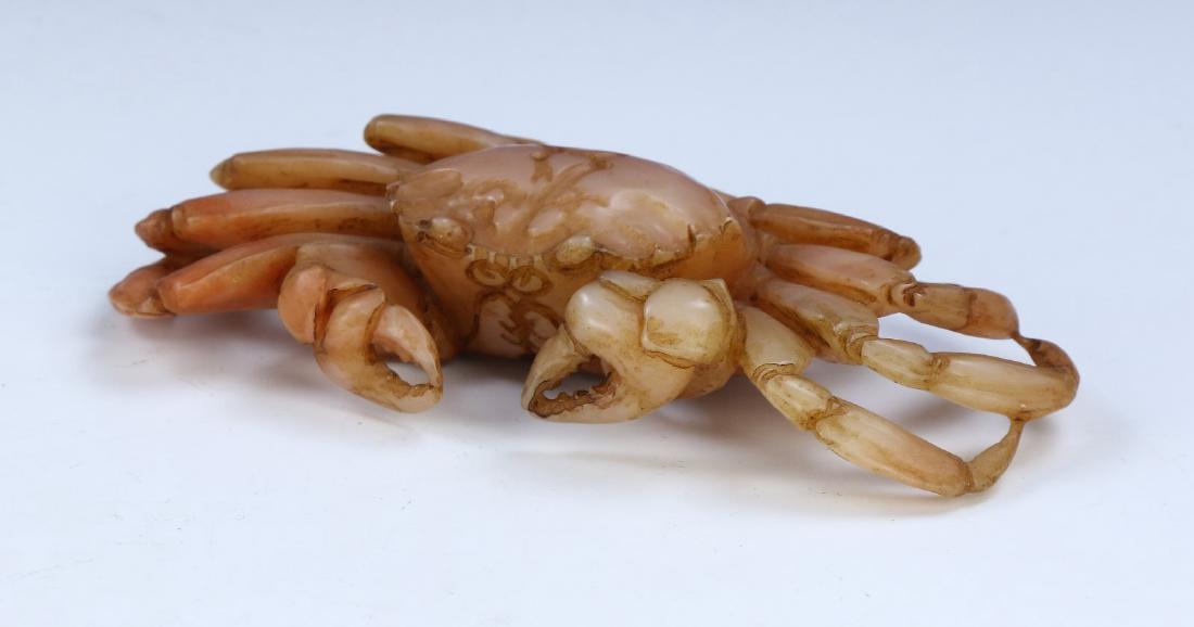 A CHINESE SHOUSHAN SOAPSTONE CRAB: A Chinese Shoushan Soapstone Crab: Finely Carved And Of Eight Legged Crab Form, The Stone Of Mottled Pale Grey To Red Tones; Size: L: 5" (12.7cm)