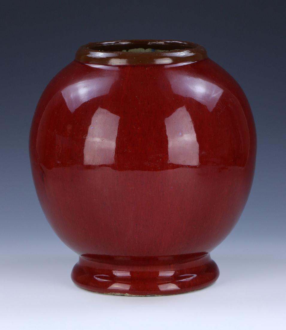 A CHINESE ANTIQUE OX BLOOD GLAZED PORCELAIN JAR: A Chinese Antique Ox Blood Glazed Porcelain Jar: Of Globular Form, Rising From A Splayed Base Rested On Low Feet To A Well Potted Body And Lipped Rim, Exterior Coated in An Even Ox Blood Tone; Size: H
