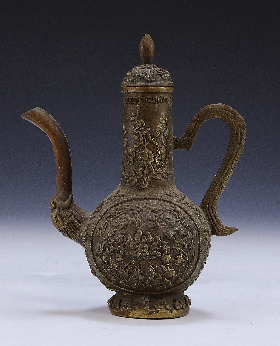 A CHINESE ANTIQUE LIDDED BRONZE VESSEL: A Chinese Antique Lidded Bronze Vessel: Of Bulbous Form, With A Small And Curling Handle Along The Body That Reaches Upwards To A Cylindrical Neck, With A High Arching Spout On One Side, Detailed Fine