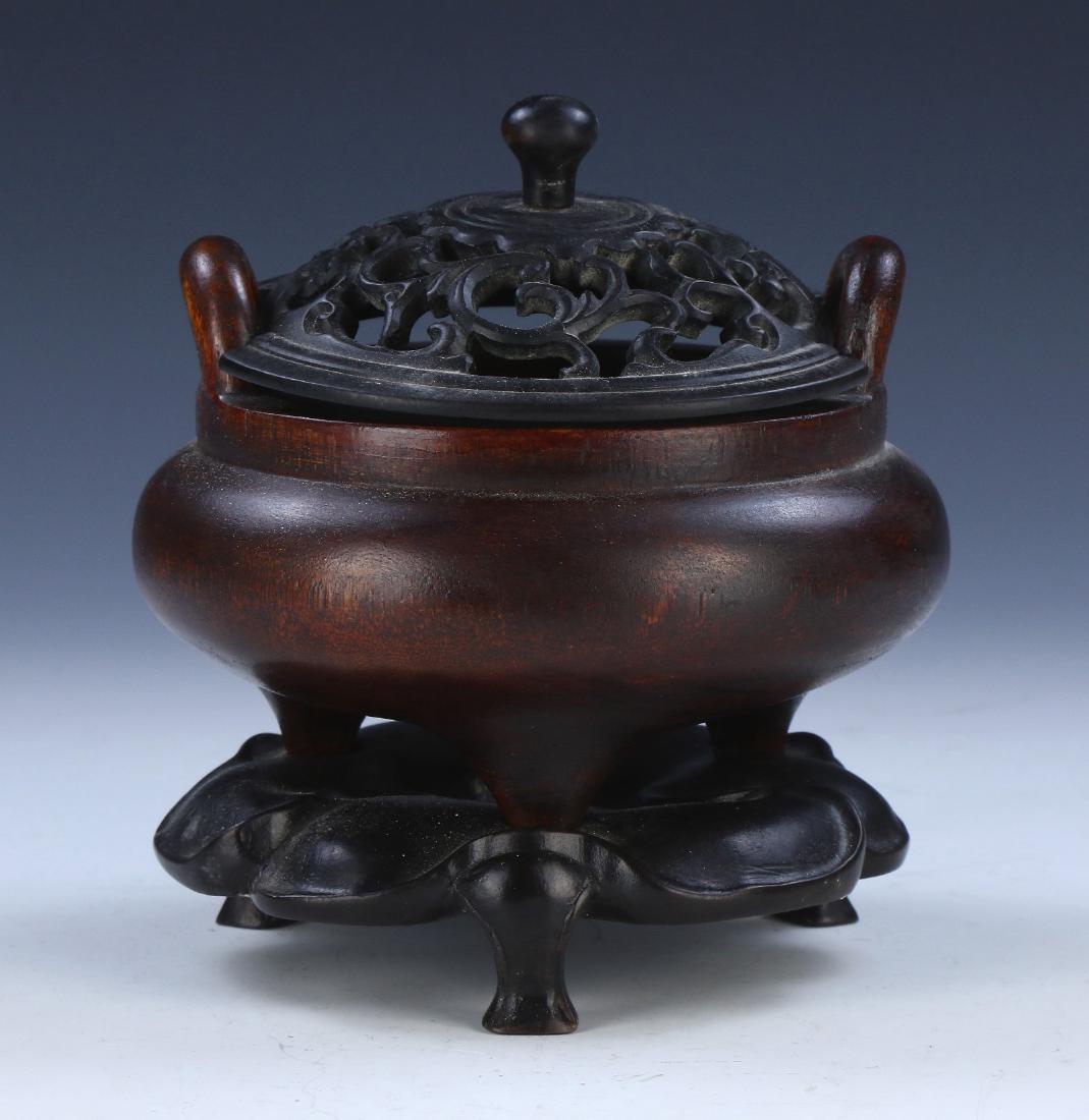 A CHINESE ANTIQUE AGARWOOD TRIPOD CENSER WITH STAND: 沉香木雕三足香爐A Chinese Antique Agarwood Tripod Censer With Stand: Finely Carved And Of Compressed Globular Form, Rising From A Base Rested On Three P