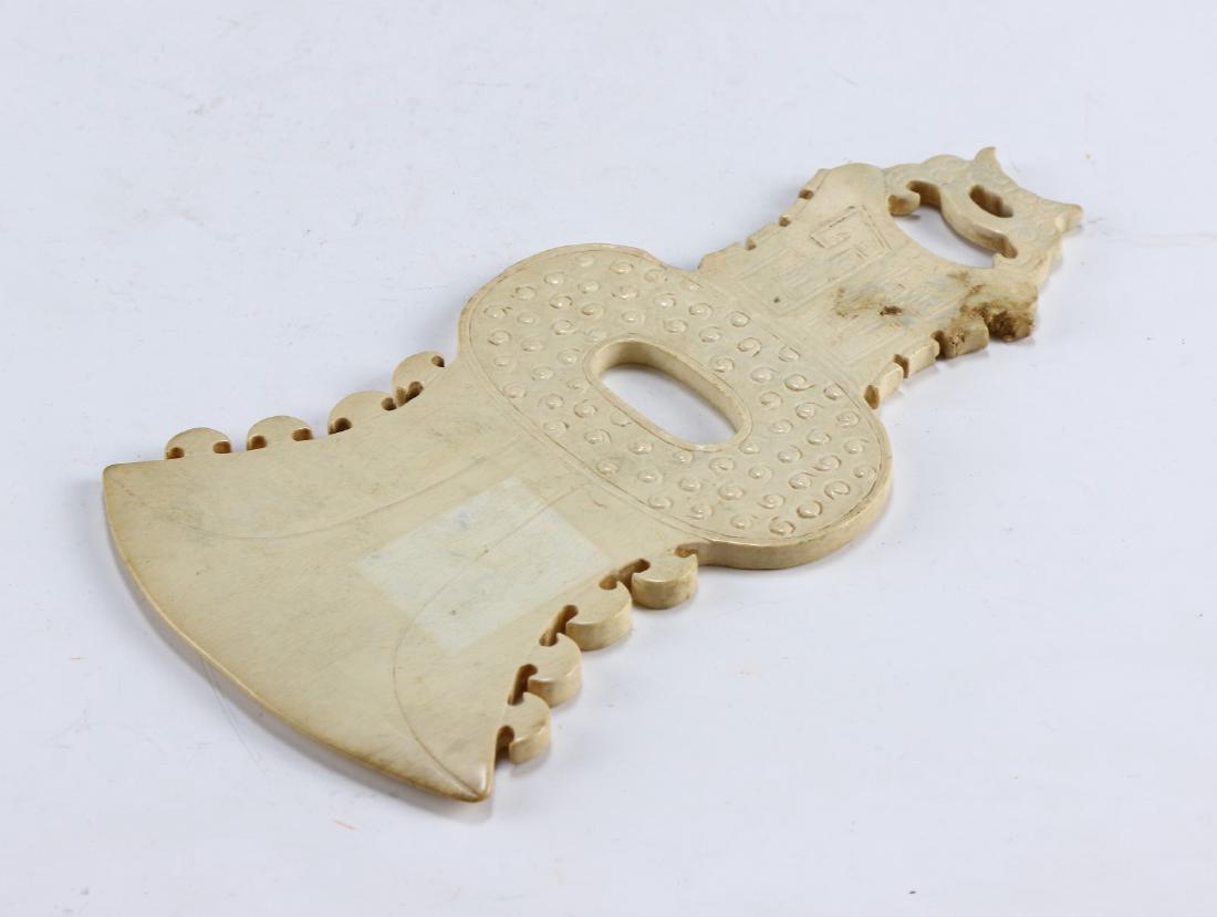 A CHINESE ANTIQUE ARCHAIC JADE CARVING: A Chinese Antique Archaic Jade Carving: Finely Carved, The Jade Of Consistent Light Tones, Mottled With Brown Spots And Streaks; Size: L: 7-3/4" (19.69cm)