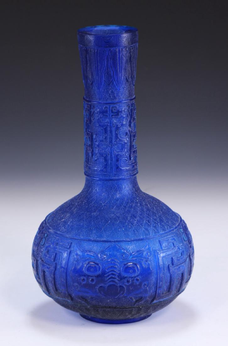 A CHINESE ANTIQUE BLUE PEKING GLASS VASE: A Chinese Antique Blue Peking Glass Vase: Finely Carved With A Globular Body, Exterior Formed With Celestial Masks And Squared Patterns, Four Character Mark incised On The Base Within A Double Square;