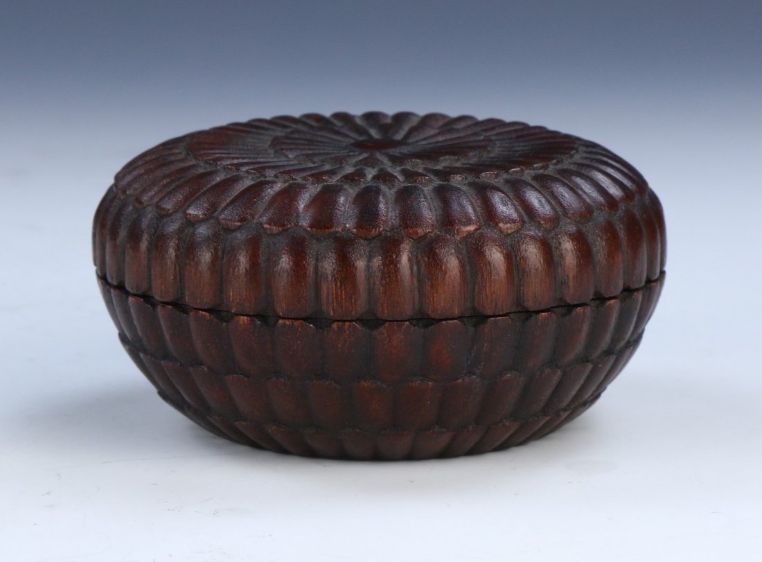 A CHINESE ANTIQUE LIDDED AGARWOOD CASE: A CHINESE ANTIQUE LIDDED AGARWOOD CASE: finely carved with rounded sides, the wood of mottled medium to dark brown tones; Size: D: 4" (10.16cm)