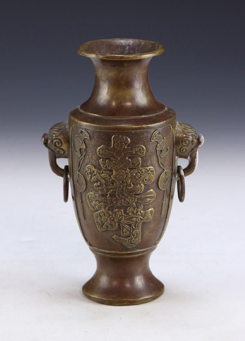 A CHINESE ANTIQUE BRONZE VASE: A Chinese Antique Bronze Vase: Of Baluster Form, Vase Shoulders Finely Molded With Menacing Masks Attached To Loose Ring Form Handles, Body Cast With Two Bats Amid Sprouting Blossoms And Scholarly Obj