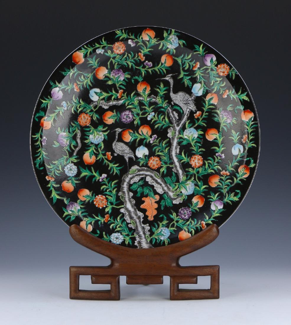 A CHINESE FAMILLE ROSE PORCELAIN PLATE WITH STAND: A Chinese Famille Rose Porcelain Plate With Stand: Finely Painted Famille Rose Plate, Comes With Brown Wooden Stand; Size: D: 14-1/2" (36.83cm) [Biggest]