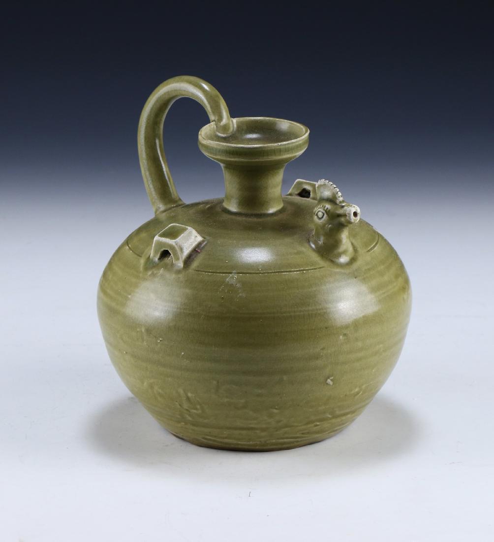 A CHINESE CELADON GLAZED PORCELAIN WINE POT: A Chinese Celadon Glazed Porcelain Wine Pot: Of Globular Form, Wine Pot Shoulders Finely Molded With A Chicken Head Form Spout And A Long C-Shaped Handle, Evenly Glazed With A Medium Tone Celadon Glaz