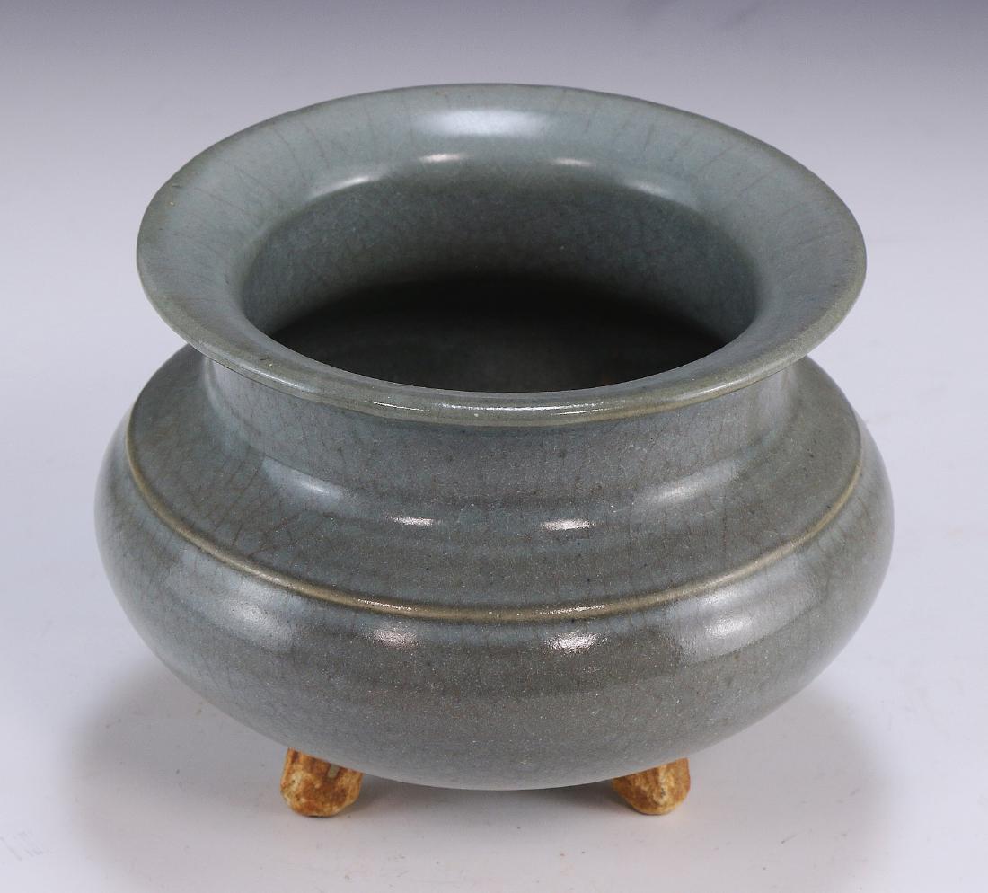 A Chinese Celadon Glazed Tri-Pod Porcelain Censer: A Chinese Celadon Glazed Tri-Pod Porcelain Censer: A Shallow Compressed Globular Body, Supported By Three Leg Stands, Extending into A Short Neck, Ending in A Flared Rim; Size: D: 6" (15cm)