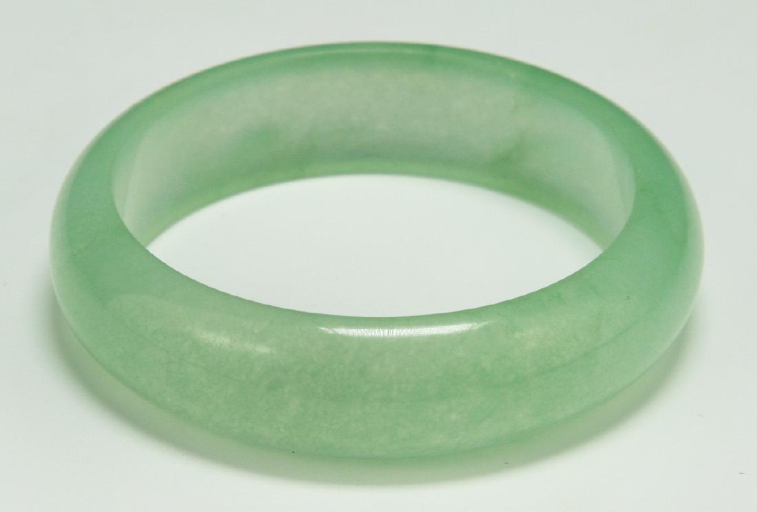 A TRANSLUCENT GREEN PEKING GLASS CARVED BANGLE (1 of 3)