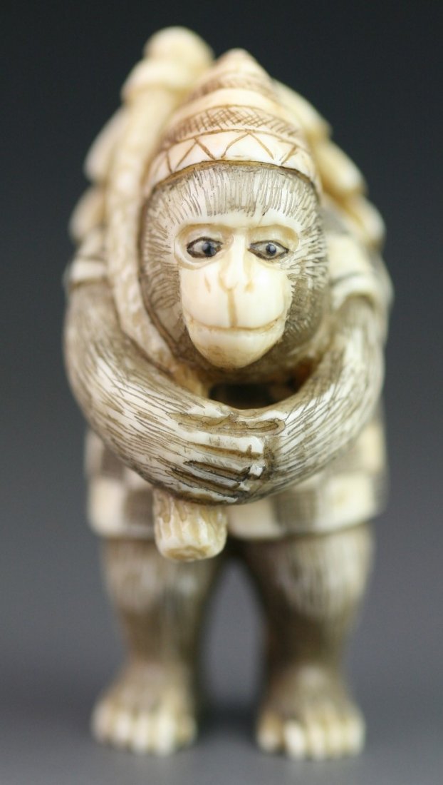 Antique Carved Ivory Netsuke: Monkey; Meizan Mark: Antique Carved Ivory Netsuke: a monkey with hat standing while carrying bags on its back; with "Meizan" Mark; H: 1-3/4"