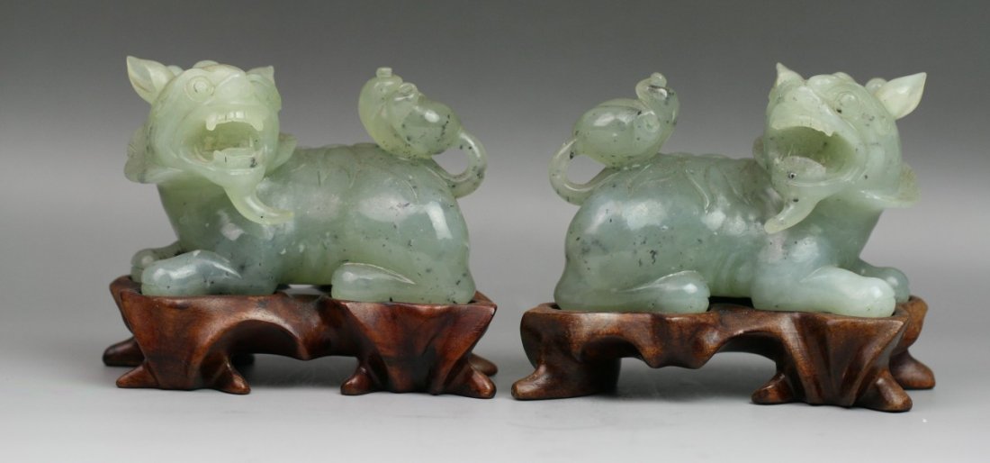 Pair Chinese Minguo Period Jade Carving: Lions: Pair Chinese Carved Jade Lions: both of resting position with mouth open wide and head turned; attached to customized matching wood stands with open work; Minguo period; L: 3-3/4" H: 3-1/4" Jade
