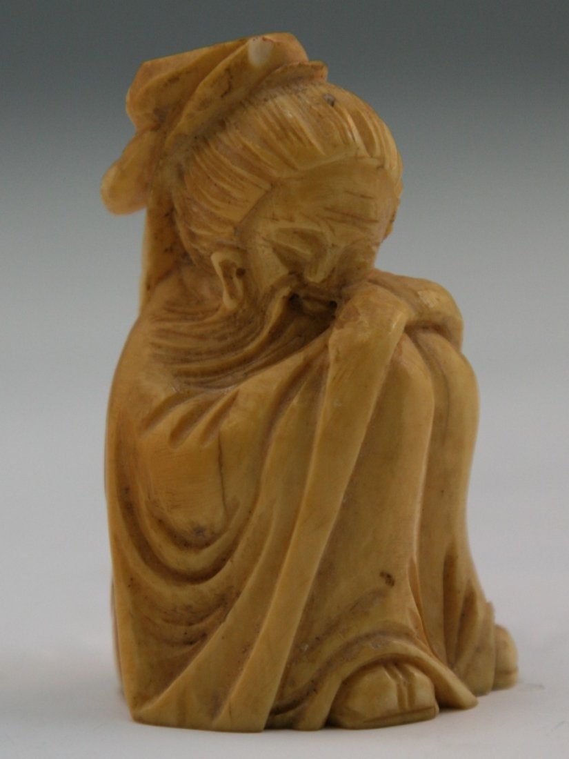 Antique Carved Ivory Netsuke: Figure: Antique carved ivory netsuke: one older man with a long beard sitting down holding his knees up while dressed in a long robe; Size: H: 2-1/4"