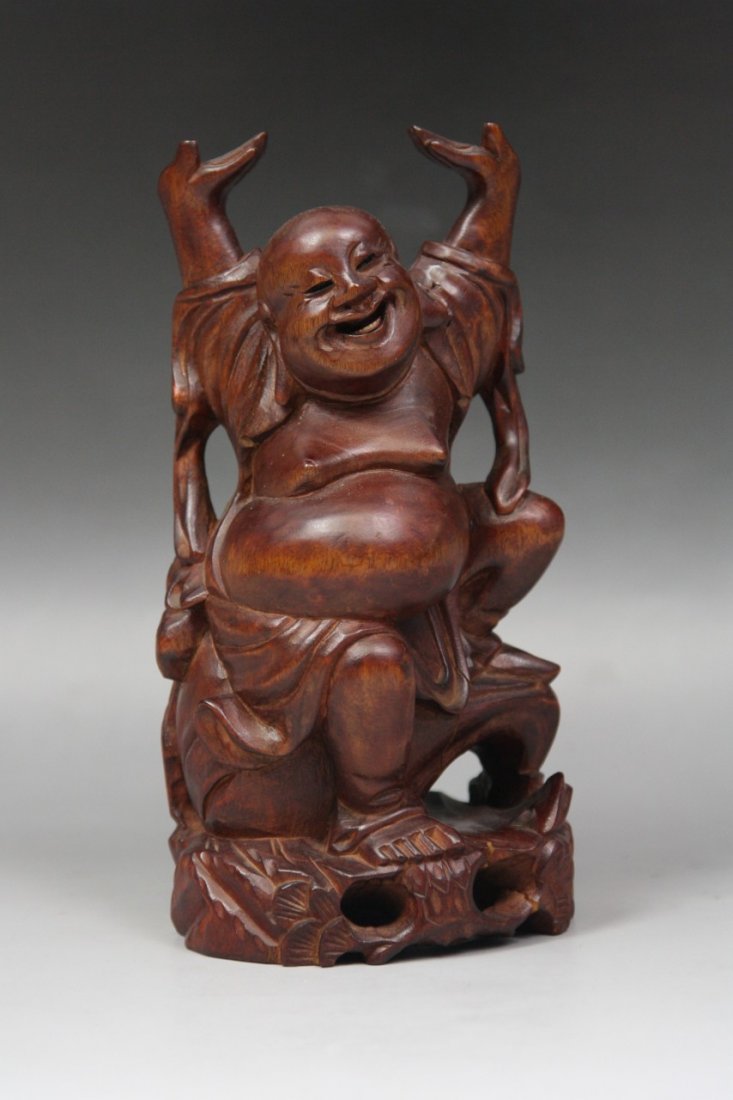 A Chinese Antique Wood Statue Of Buddha: A Chinese Antique Wood Statue of Buddha: carved from the wood with warm dark brown tone as a laughing Buddha seated on a rockwork while both arms up, Minguo Period; Size: H: 7-1/4"