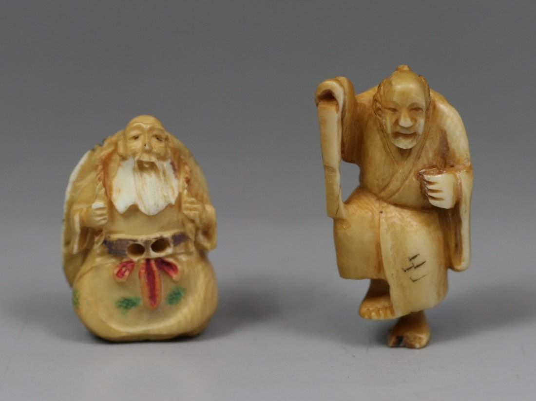 Pair Of Antique Polychrome Ivory Netsukes: Pair of Antique Polychrome Ivory Netsukes: one old bearded man standing with a large turtle shell strapped to his back, together with a man standing on one leg while carrying a stick in his right hand