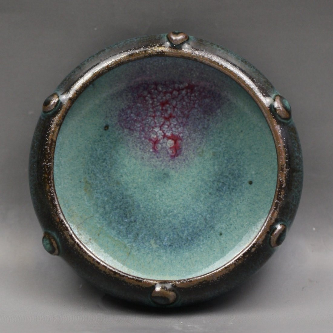 A Chinese Junyao Brush Washer: A Chinese JUNYAO Brush Washer: stoutly potted as circular form, applied outside and inside with a thick pale blue glaze suffused with crackle while with some bright crimson, with a band of raised boss