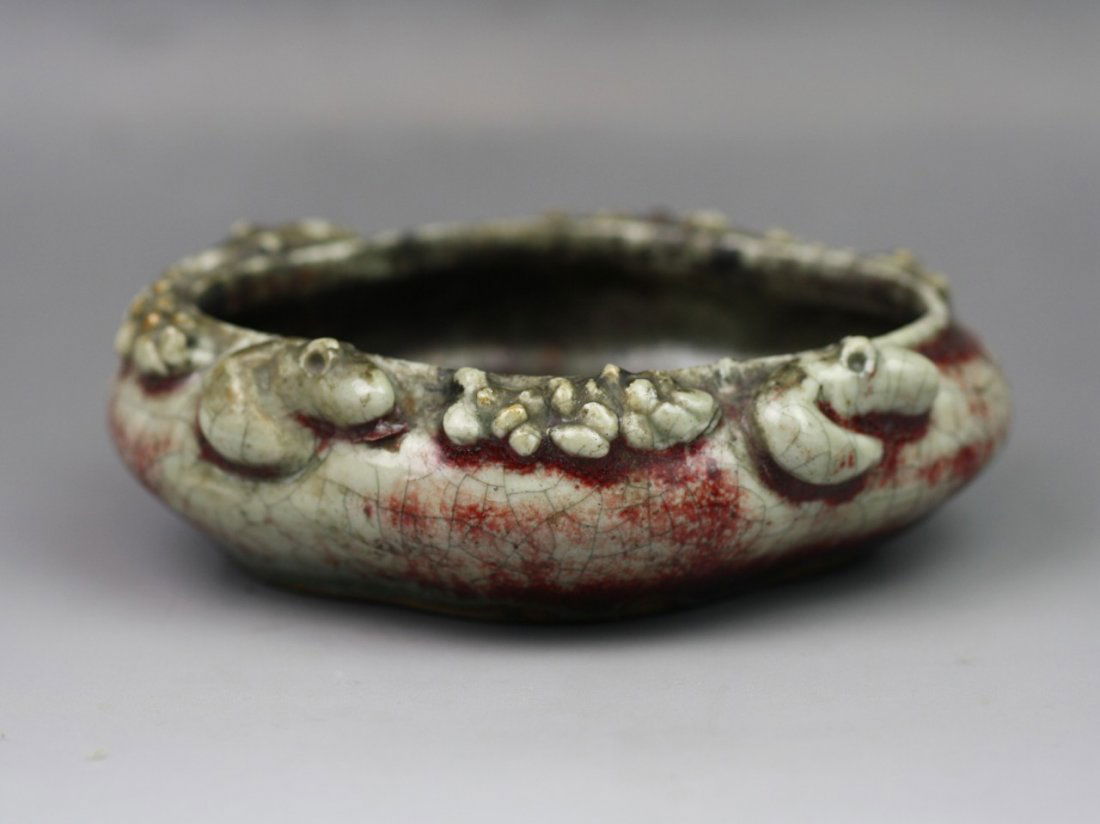 A Qing Dynasty Chinese Porcelain Brush Washer: A Qing Dynasty Chinese Porcelain Brush Washer: applied with an imperfect ox-blood glaze suffused with crackle while with some bright crimson, molded with bats and "Chi Dragon" encircled around the rim