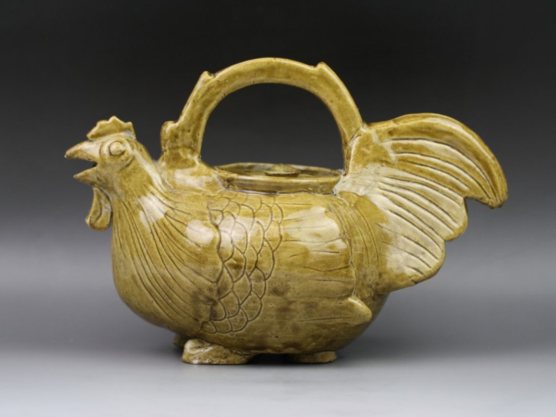 A Tang Dynasty Brown-Glazed Chicken-Head Tea Pot: A Tang Dynasty Brown-Glazed "Chicken-Head" Tea Pot: of robust globular body and the shoulders set with a 'chicken-head' spout flanked by a handle with chicken tail to the opposite, all raised from fou