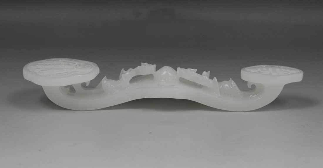 A Chinese White Jade Ruyi Sceptre: A Chinese White Jade Ruyi Sceptre: very elaborately carved as a ruyi has a long S-shaped handle and a head fashioned like a lingzhi mushroom decorated with bat and character 'Shou', the handle carved 