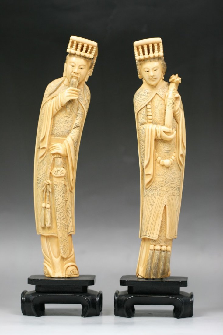 A Pair Of Chinese Carved Emperor And Empress: A Pair of Chinese Carved Emperor and Empress: elaborately carved, each with ornate detailed robes and headdresses: he holds his beard in one hand while holding a sword down with his other hand: she we