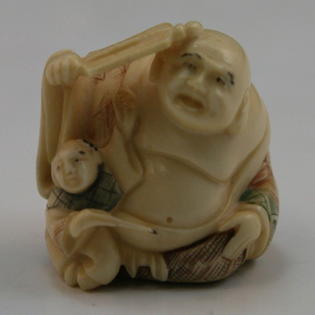 Antique Carved Ivory Netsuke: Figures: Antique carved ivory netsuke: Antique ivory netsuke: one heavy set man sitting down with an open robe on holding a fan to his head while a young child sits to his right side; Size: H: 1-1/4"